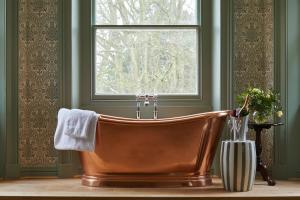 eine Kupferbadewanne im Bad mit Fenster in der Unterkunft The Retreat, Elcot Park in Newbury