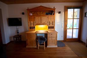 einen Schreibtisch in einem Zimmer mit einem TV und einem Fenster in der Unterkunft Haus Heufelder in Bad Heilbrunn