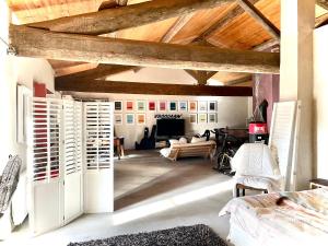 - un salon avec un plafond en bois et une table dans l'établissement Maison Antonia, à Marsillargues