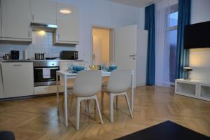 una cucina con tavolo e sedie bianche di Jimmy's Apartments Suites a Vienna