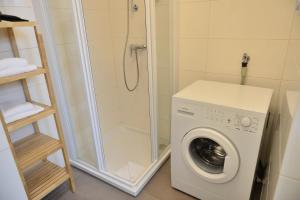 een wasmachine in een badkamer met een douche bij Jimmy's Apartments Suites in Wenen