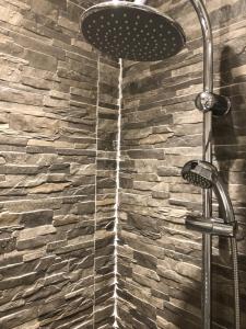 a shower in a bathroom with a stone wall at Anson Studios Walsall M6, J10 in Walsall