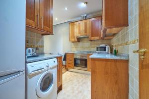 馬德里的住宿－BV Rooms，厨房配有木制橱柜、洗衣机和烘干机