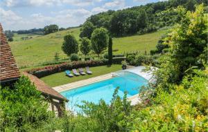 a swimming pool with chairs and a hill in the background at Stunning Home In Domfront En Champagne in Domfront-en-Champagne