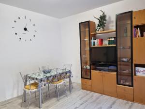 mesa de comedor con sillas y reloj en la pared en Stella Marina House -citra 010047LT-0127, en Recco