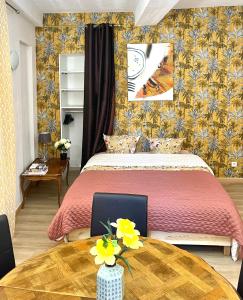 een slaapkamer met een bed en een tafel met een laptop erop bij Art Apparts coeur de ville in Béziers