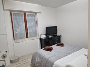 Habitación blanca con cama y TV en Stella Marina House -citra 010047LT-0127, en Recco