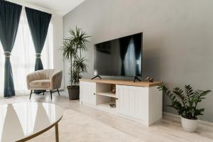 a living room with a tv on a white cabinet at East Side Living & Terrace in Braşov