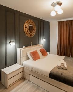 a bedroom with a large white bed with a mirror on the wall at East Side Living & Terrace in Braşov