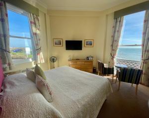 a bedroom with a bed with a view of the ocean at Langham Hotel Eastbourne in Eastbourne