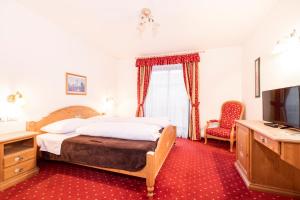 a hotel room with a bed and a television at Hotel Restaurant Putzer in Naz-Sciaves