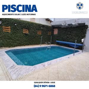 a swimming pool in front of a wall at Casa com piscina, churrasqueira, 3 suítes com ar condicionado in Caldas Novas