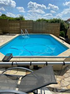 una gran piscina azul en el patio trasero en Maison 6 personnes avec piscine privée, en Saulchoy