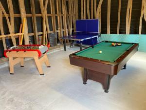 a room with a pool table and a chair at Maison 6 personnes avec piscine privée in Saulchoy