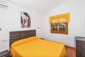 カラ・ブランカにあるTheaのベッドルーム1室(黄色いベッド1台、窓付)