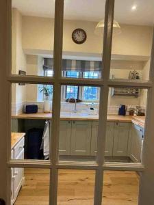 a view of a kitchen through a sliding glass door at The Manor Stables in Sturminster Newton