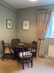 a dining room with a table and chairs and a window at The Manor Stables in Sturminster Newton