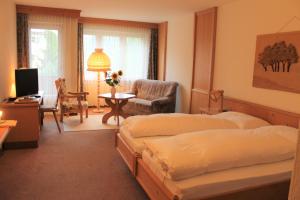 a bedroom with two beds and a chair and a desk at Gemeinschaftshaus im Oberdorf in Lützelflüh