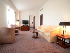 a living room with a couch and a tv at Hotel Bientos in Tosu