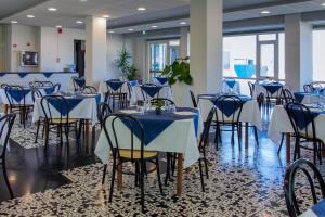 a banquet hall with blue tables and chairs at Hotel President's in Pesaro