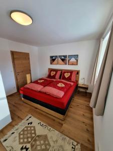 ein Schlafzimmer mit einem roten Bett in einem Zimmer in der Unterkunft Ferienwohnung Kurz in Kössen