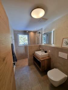 W łazience znajduje się toaleta, umywalka i lustro. w obiekcie Ferienwohnung Kurz w mieście Kössen +26 zdjęć