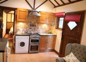 een kleine keuken met een fornuis en een wasmachine bij The Stable in Hailsham