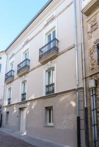 a white building with balconies on a street at Lumen Place APARTAMENTOS in Mondoñedo