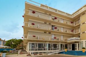 a hotel with balconies and stairs in front of a building at Hotel President's in Pesaro
