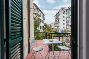 a patio with a table and chairs on a balcony at Marimat in Florence