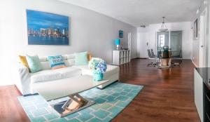 uma sala de estar com um sofá branco e uma mesa em Dream Vacation Apartment Right On The Beach em Hollywood