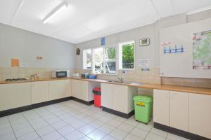 a large kitchen with white cabinets and a counter at Narooma Motel in Narooma