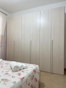 a bedroom with a bed with wooden cabinets at Casa Elena in Dorgali