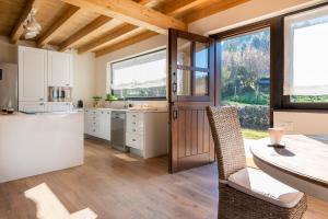 cocina con armarios blancos y techo de madera en Fidalsa North Style, en Arosteguieta