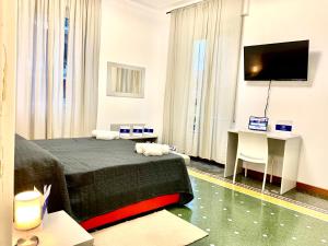 Dormitorio con cama, escritorio y TV en House Nervi 2 by Holiday World en Génova