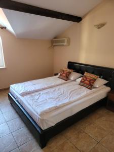 a bedroom with a bed with white sheets and pillows at Villa Favorita in Eforie Sud