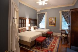 a bedroom with two beds and a table and chairs at The Marshall House, Historic Inns of Savannah Collection in Savannah