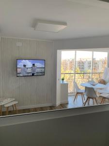 ein Wohnzimmer mit einem Tisch und einem TV an der Wand in der Unterkunft Apartamento Salou Playa Jaime I in Salou