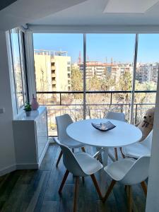 una mesa y sillas blancas en una habitación con una ventana grande en Apartamento Salou Playa Jaime I, en Salou