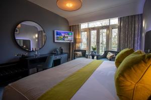 a hotel room with a large bed and a mirror at Fota Island Hotel and Spa in Cork