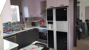 a kitchen with a black refrigerator and a sink at VILLA BY THE SEA VRAVRONA LOUTSA(NEAR THE AIRPORT&METROPOLITAN) in Athens