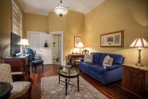 a living room with a blue couch and a table at The Marshall House, Historic Inns of Savannah Collection in Savannah