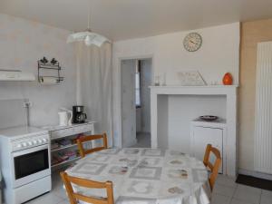 a kitchen with a table and a kitchen with a stove at Chez Florine et Valentin in Gigny