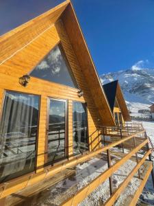 a log cabin with a large window on the deck at AURA Cottages in Kazbegi