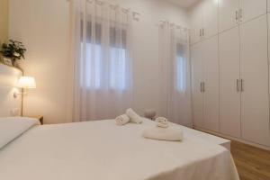 een witte slaapkamer met 2 handdoeken op een bed bij Apartamento Las 3 Gaviotas in Cádiz