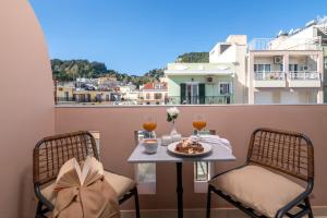 un tavolo e sedie su un balcone con bicchieri da vino di Maison Downtown Luxury Apartments! a Città di Zante