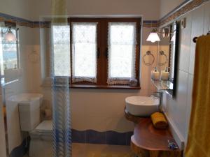 a bathroom with a sink and a toilet and a window at Pines of Salgado beachview villa by Book YourHoliday PT in Nazaré +26 photos