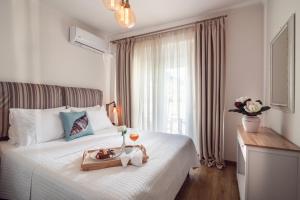 a bedroom with a bed with a tray of food on it at Maison Downtown Luxury Apartments! in Zakynthos