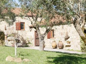a stone house with two large vases in front of it at Pines of Salgado beachview villa by Book YourHoliday PT in Nazaré