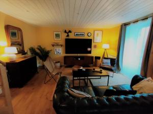 a living room with a couch and a flat screen tv at Maison de pêcheur Port de plaisance Tréboul in Douarnenez